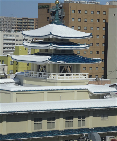 雪が薄く積もった富山西本願寺の塔